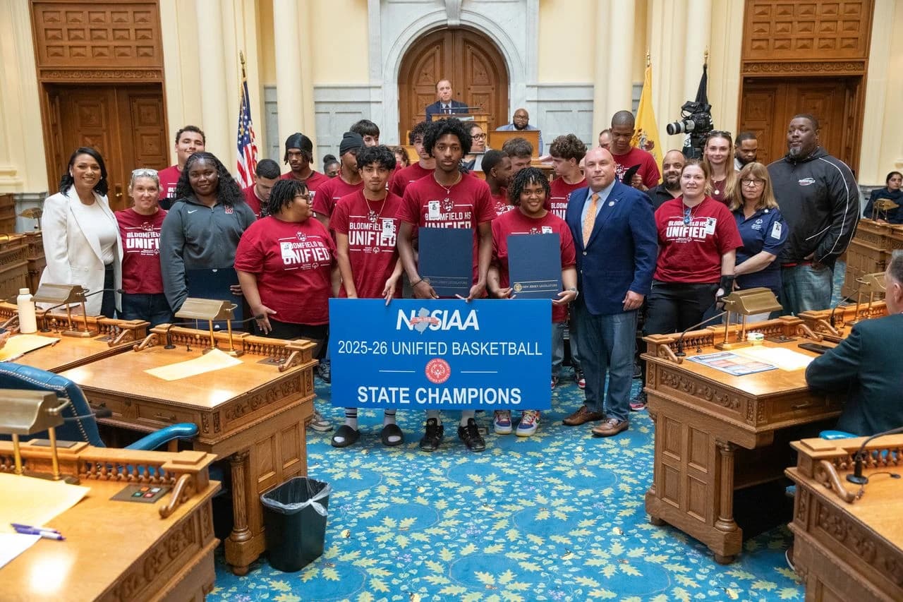 Assemblywoman Carmen Morales at the left of a group wearing Bloomfield HS Unified shirts in the legislative chamber