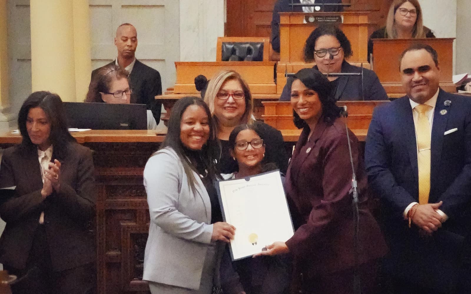 Assemblywoman Carmen Morales presenting a State House recognition to a District 34 family